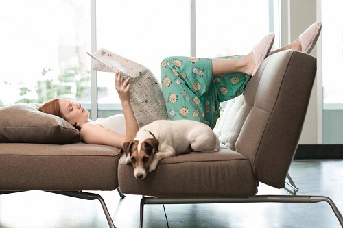 Femeie relaxându-se împreună cu animalul său de companie