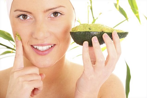 Femeie aplicând o mască de avocado