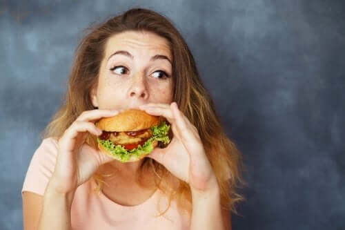 Femeie mâncând un hamburger