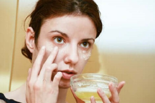 Femeie aplicând un tratament facial