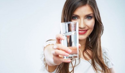 Femeie care bea un suc pentru curățarea naturală a intestinelor