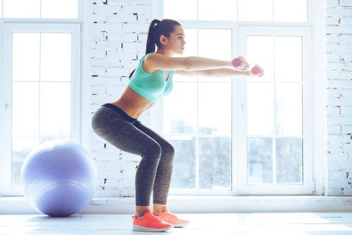 Femeie încercând exerciții simple pentru modelarea siluetei acasă