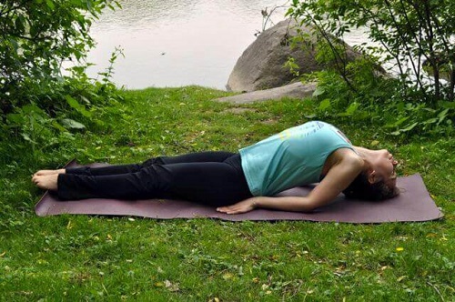 Femeie adoptând poziții de yoga pentru arderea grăsimii