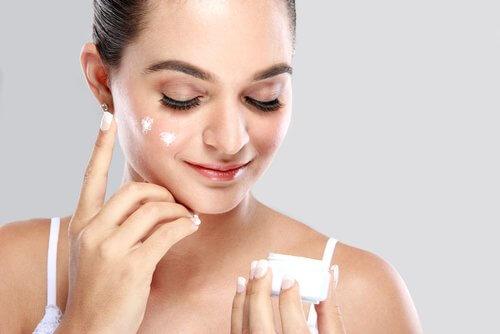 Femeie care folosește cremă regeneratoare cu aloe vera