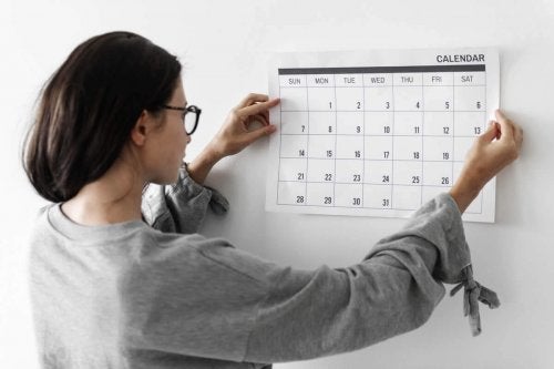 Femeie care pune un calendar pe perete