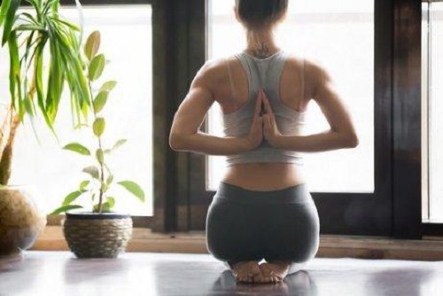 Poziție de yoga cu mâinile la spate