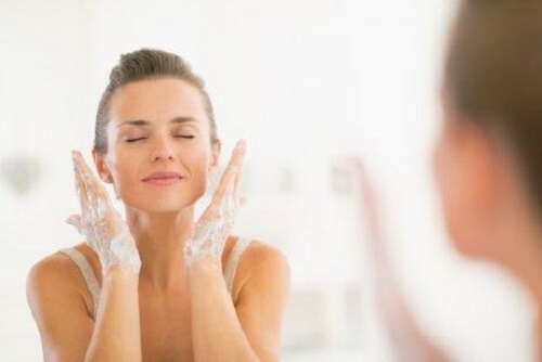 Femeie care se spală pe față