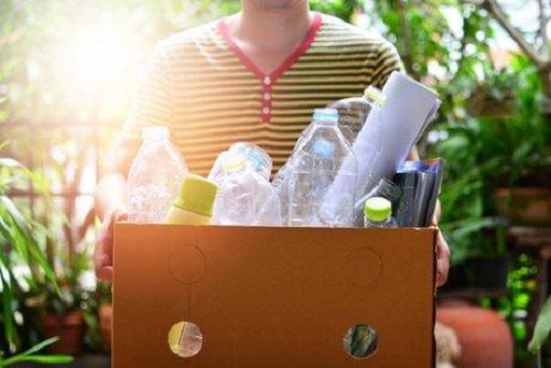 Bărbat care reciclează plastic și hârtie