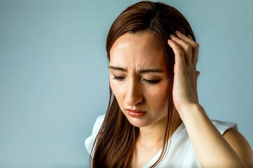 Femeie care suferă o migrenă
