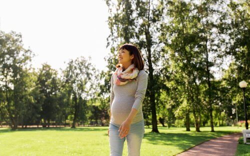 Femeie însărcinată care merge pe jos