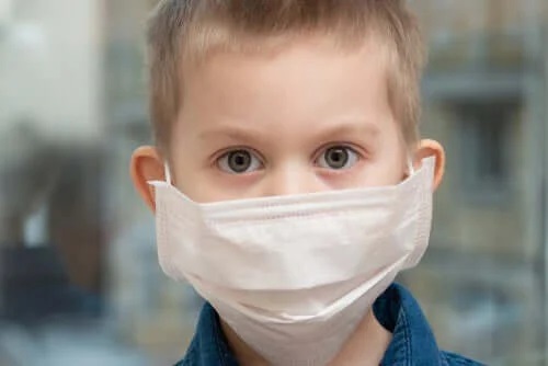 Copil care poartă mască pentru coronavirus