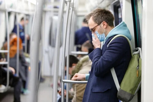 Bărbat cu mască de protecție în metrou