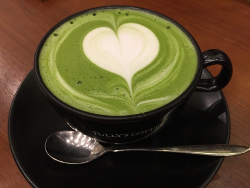 Cană de ceai verde cu spumă în formă de inimă