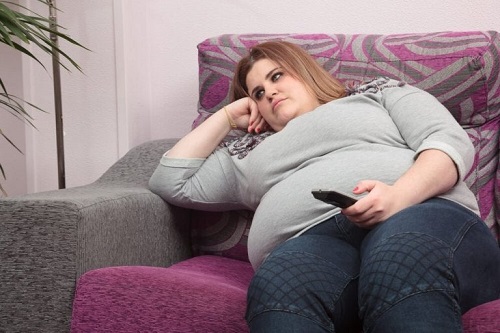 Femeie obeză uitându-se la televizor