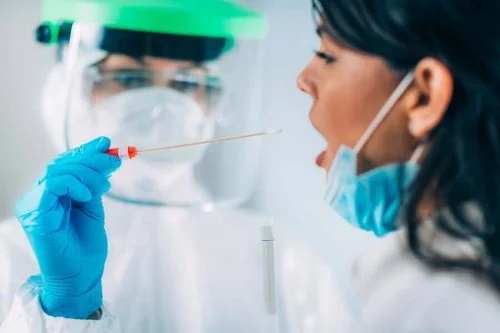 Medic care recoltează probă din gât