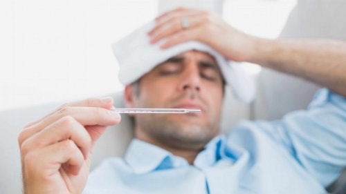 Bărbat luându-și temperatura cu un termometru