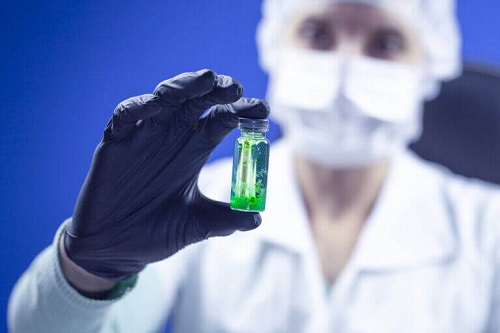 Cercetător care ține în mână o fiolă