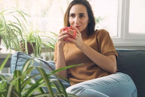 Femeie care profită de reducerea timpului pe mobil bând cafea