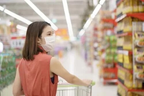 Femeie care face cumpărături purtând o mască