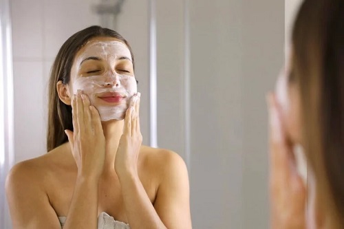 Femeie care își aplică o masă facială