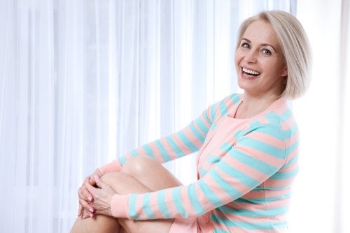 Femeie cu părul grizonat îmbrățișând schimbările care survin la menopauză