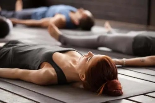 Femeie care practică tehnici de relaxare în grup