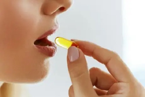 Femeie care ia un supliment de vitamina K