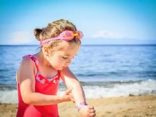 Fetiță la plajă în costum de baie