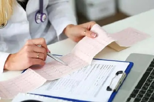 Medic care citește o electrocardiogramă