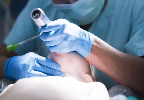 Medic aplicând secvența de inducție rapidă unui pacient