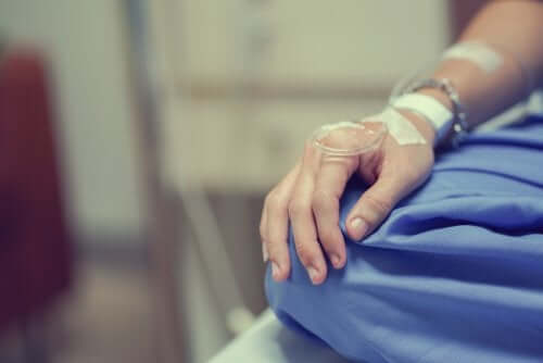 Perfuzie intravenoasă introdusă în mâna unui pacient cu cancer