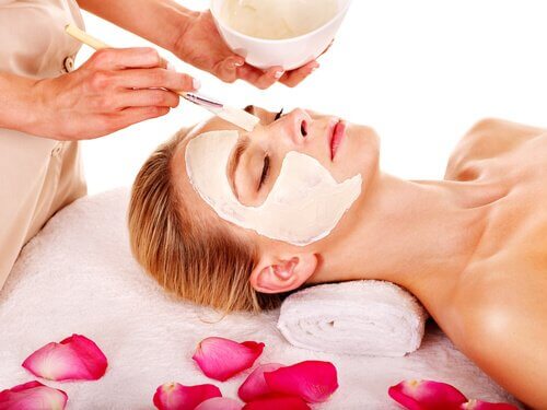 Specialist aplicând măști faciale naturale pentru o pacientă