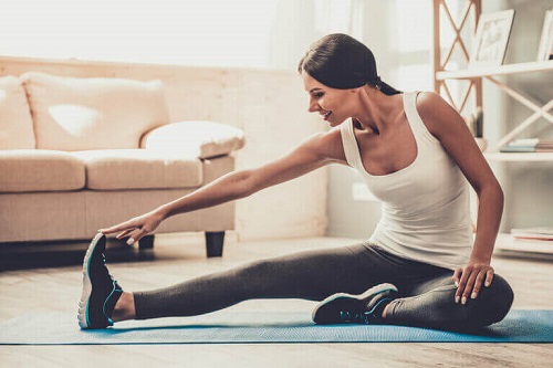 Femeie care face sport acasă în timpul pandemiei de coronavirus