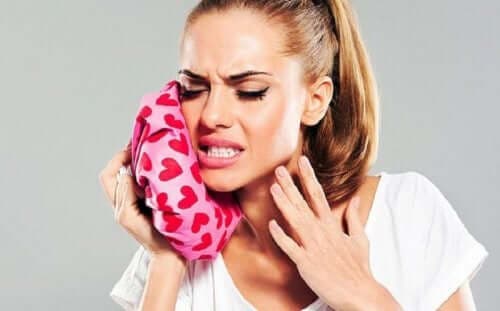 Femeie stimulând ameliorarea durerii de dinți cu gheață