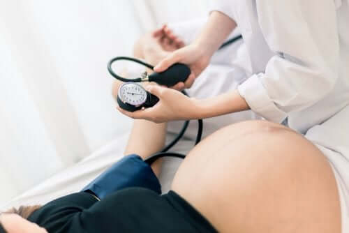 Medic luând tensiunea unei gravide