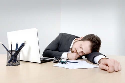 Bărbat care doarme cu capul pe birou