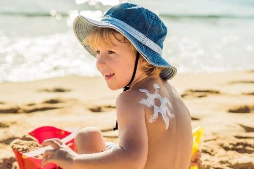 Copil cu o stea din cremă de protecție solară pe spate