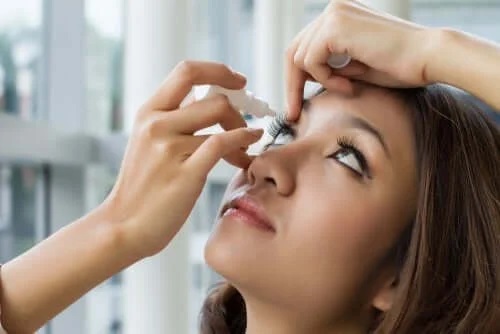 Fată care își pune în ochi soluția oftalmică cu oximetazolină