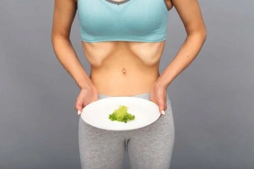 Femeie care ține o farfurie cu o frunză de salată