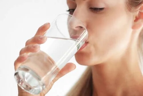 Femeie care se hidratează bând apă