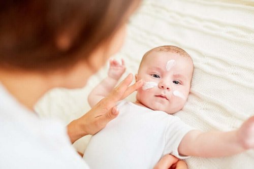 Mămică aplicând un tratament pentru dermatita atopică la bebeluși