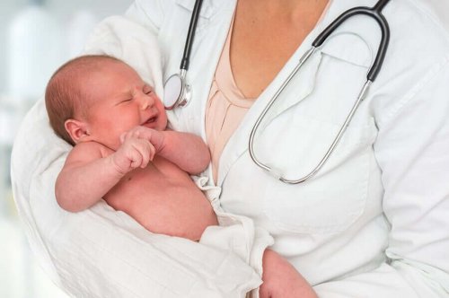 Medic ținând un bebeluș în brațe