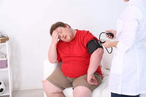 Medic luând tensiunea unui pacient obez