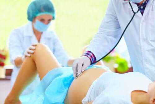 Medici ajutând o gravidă să nască