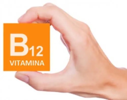 Mână care ține un cub pe care scrie vitamina B12