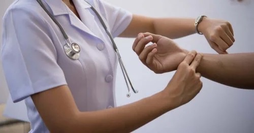 Asitentă care explică cum să îți iei pulsul