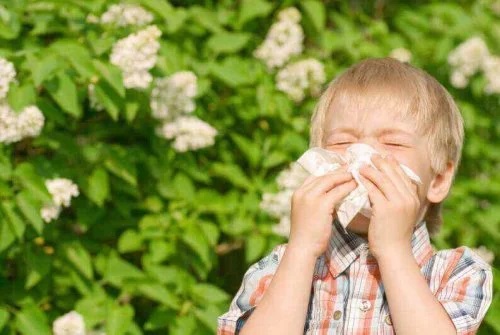 Copil care își suflă nasul