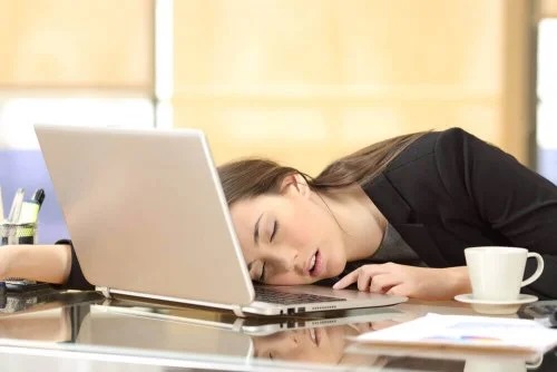 Fată care doarme cu capul pe laptop