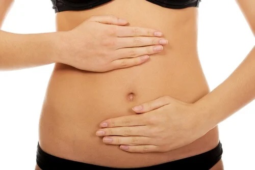 Femeie cu mâinile pe abdomen