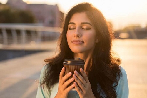 Femeie care bea cafea în oraș